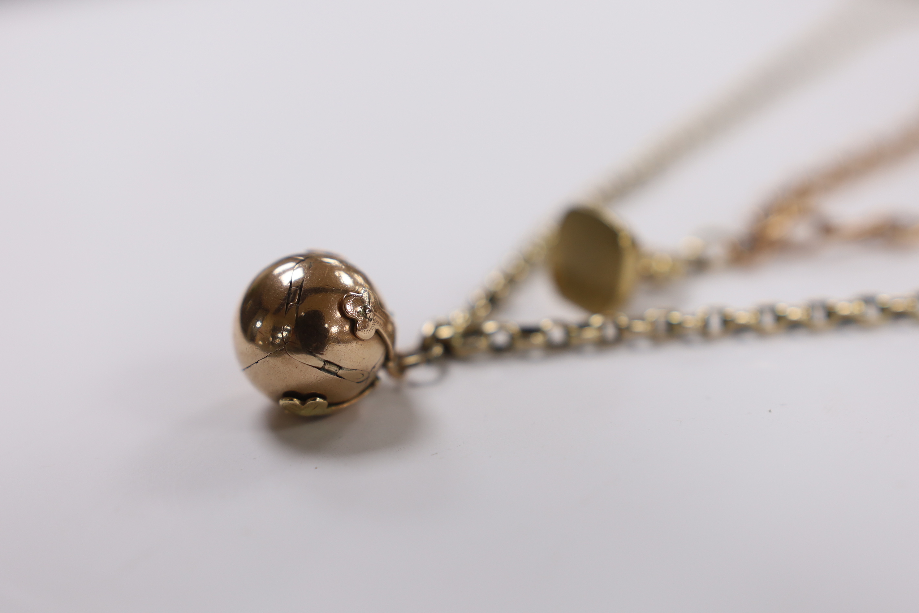 A yellow metal overlaid fob seal on a damaged 9ct gold bracelet, together with a yellow metal masonic ball on a yellow metal chain.